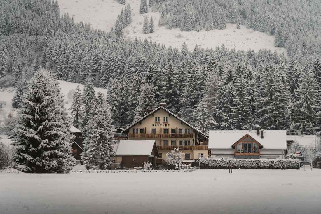 Una baita in legno tra gli abeti coperti di neve